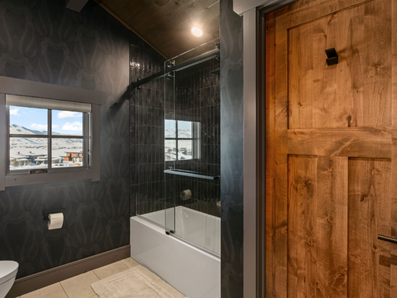 Custom bathroom with black walls and wooden door