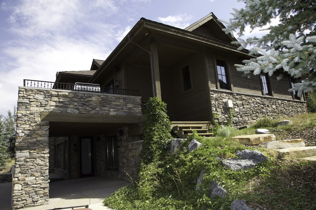 Stone remodel of exterior home with custom car port