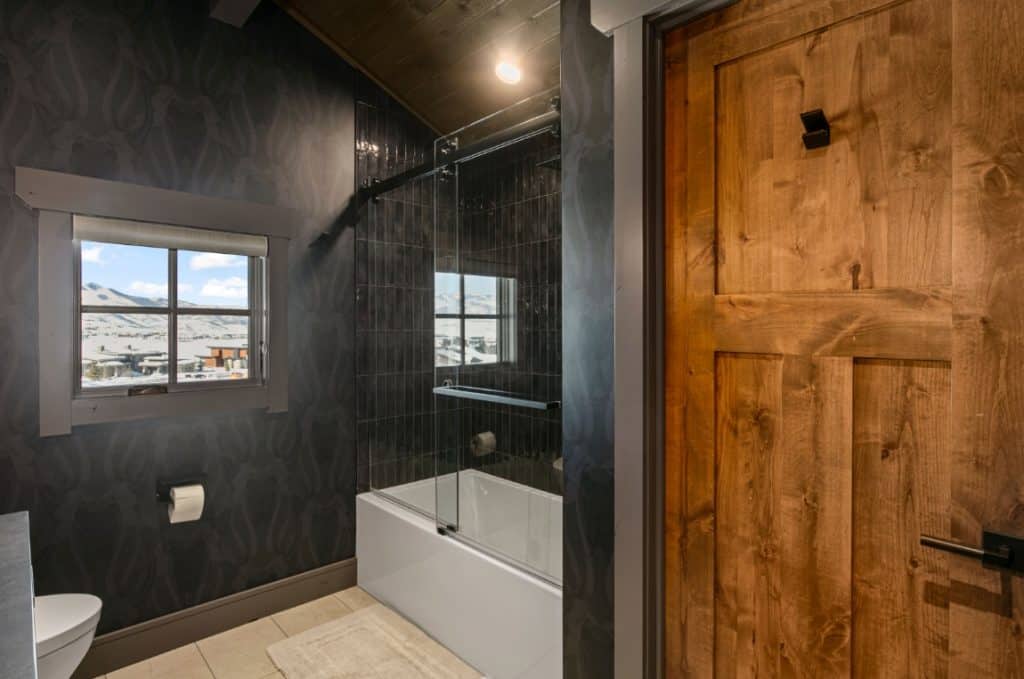 Custom bathroom with black walls and wooden door