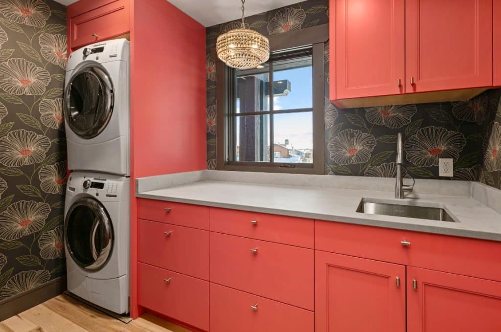 Laundry room with red cabinets and shelving